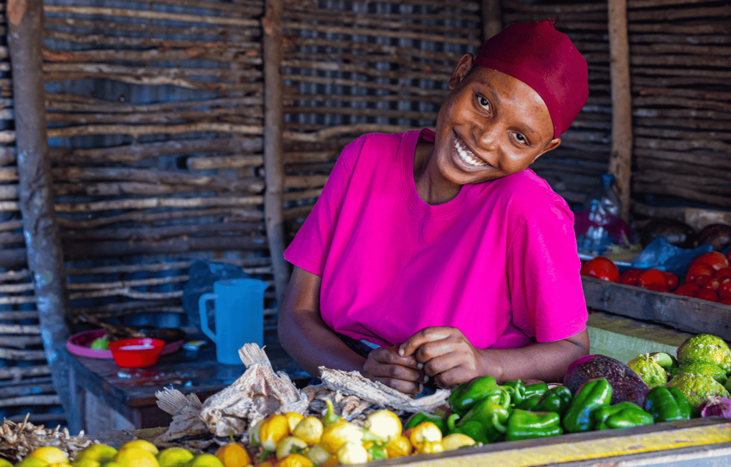 Young woman smiling at a produce stall in Tanzania
