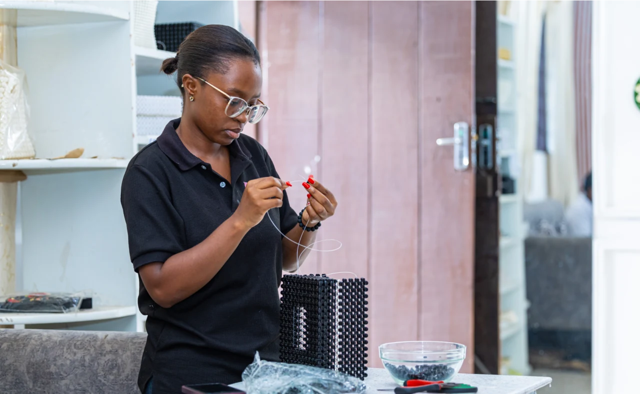 Young woman working carefully on a beaded craft project