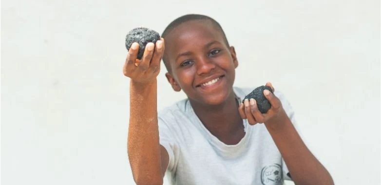 Young person smiling while holding materials