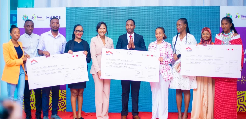 Participants holding large cheques on a stage