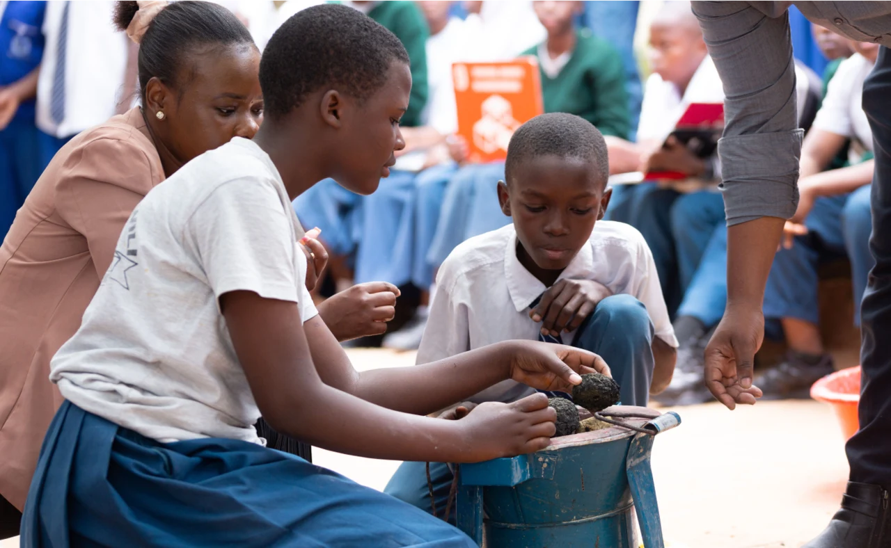 Students gathered around a practical exercise during a youth development session